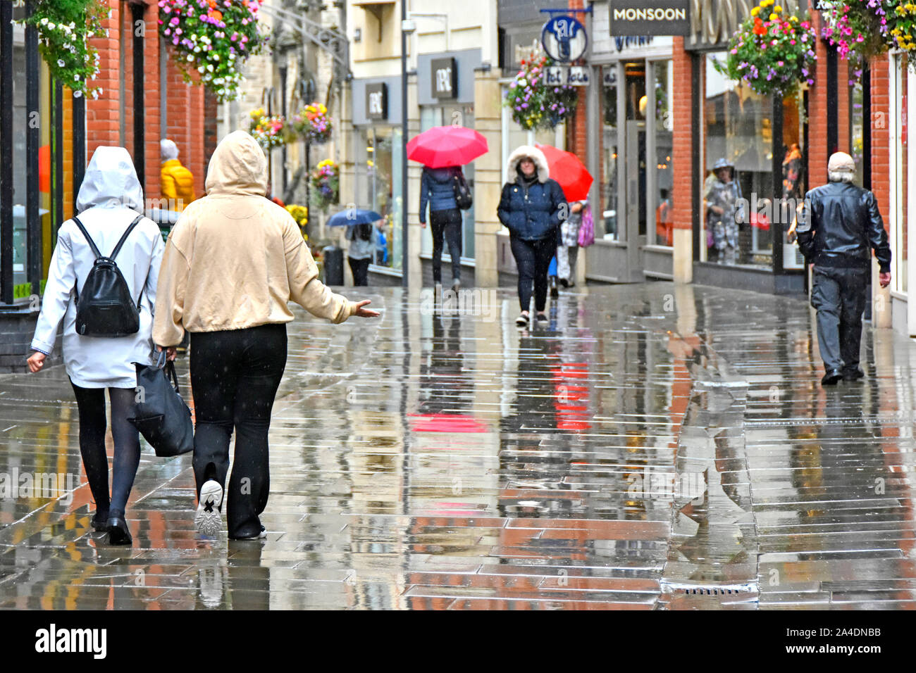 Scène de rue à pleuvoir sur les gens par temps humide centre ville piétons dans la zone de shopping street réflexion pluie & réflexions Durham England UK Banque D'Images