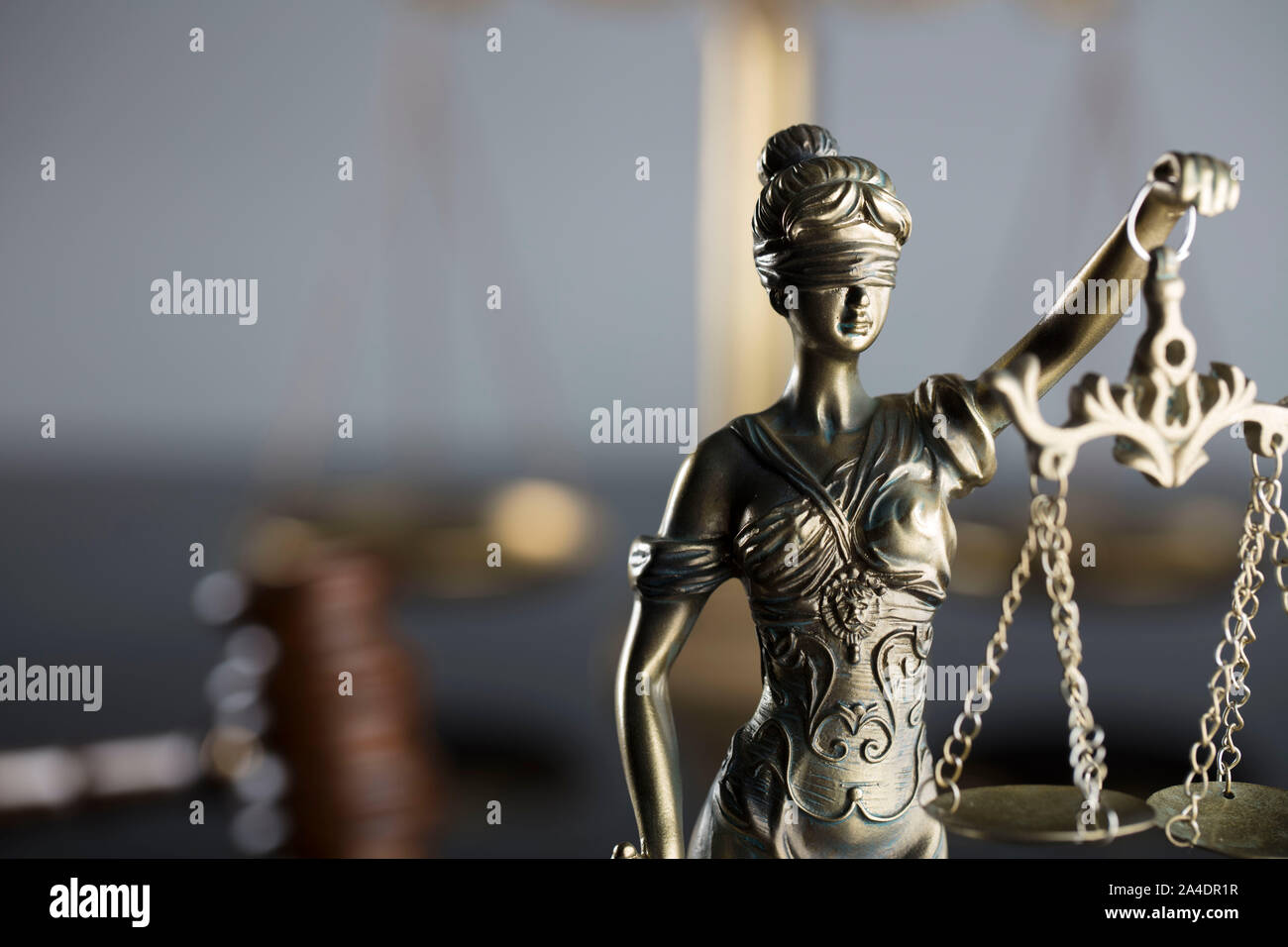 Concept de la Justice. Statue de Themis, l'échelle et judge's gavel sur la table en verre et le fond gris. Banque D'Images