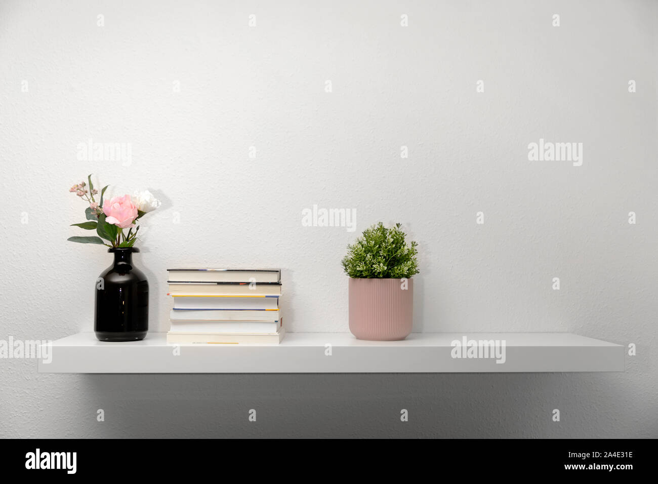 Bookshef sur mur blanc avec décorations Banque D'Images