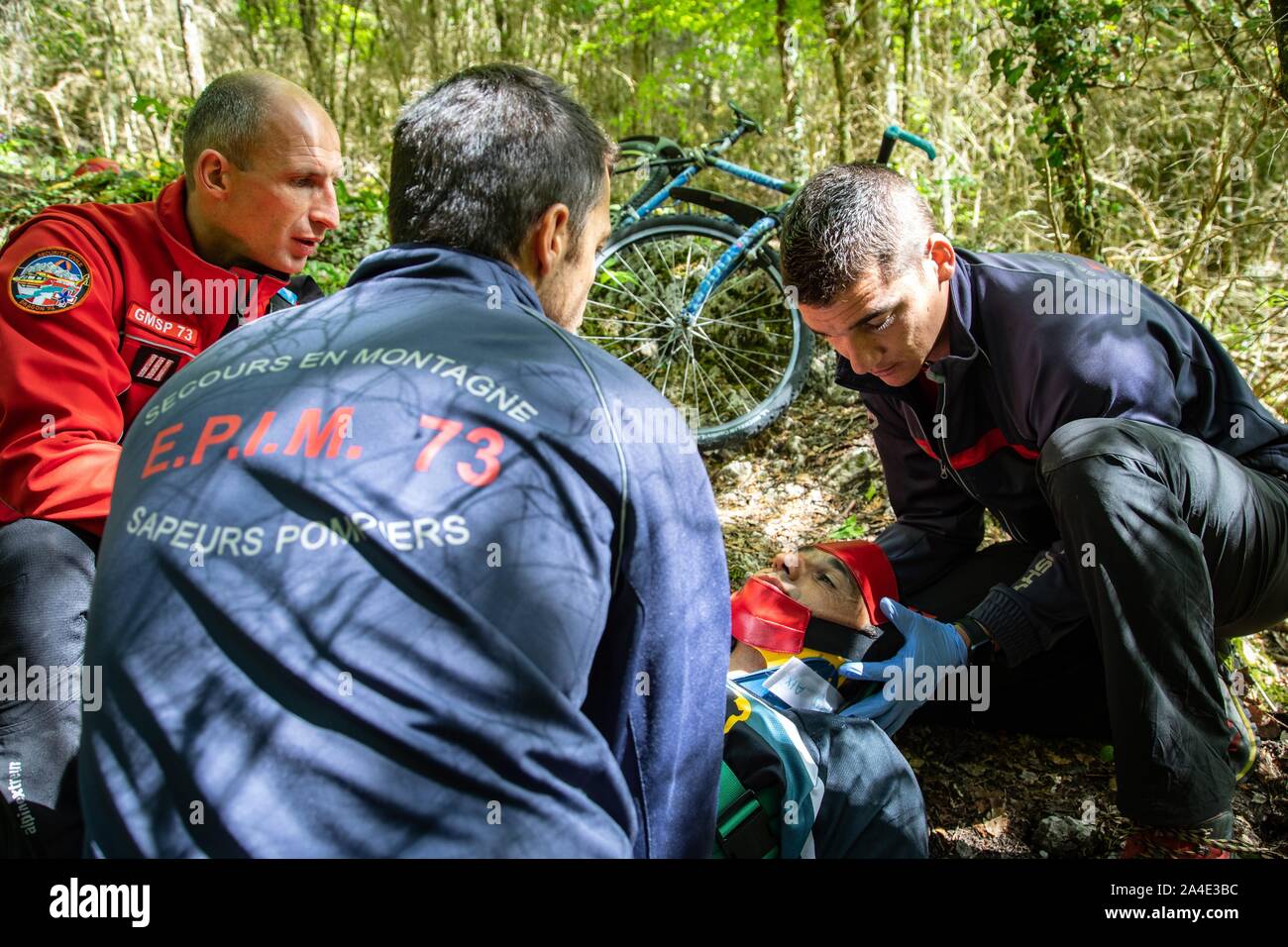 INTERVENTION DE LA PREMIÈRE INTERVENTION DE L'ÉQUIPE DE SECOURS EN MONTAGNE POUR UN TOMBÉ DU VÉLO DE MONTAGNE AVEC UNE SUSPICION DE FRACTURE DE LA JAMBE, LA FORÊT DE RHONNE CI-DESSUS DU LAC DU BOURGET, LA CHAPELLE DU MONT-DU-CHAT (73), FRANCE Banque D'Images