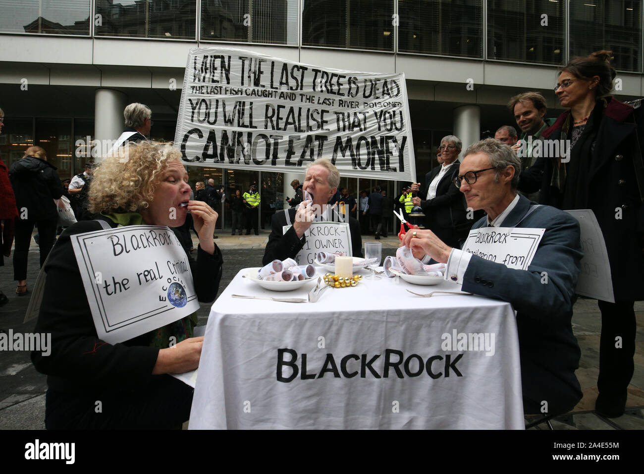 'Argent' manifestants manger comme une forme de manifestation devant le siège de BlackRock dans Throgmorton Street à Londres, au cours d'une rébellion d'Extinction (XR) changement climatique de protestation. Banque D'Images