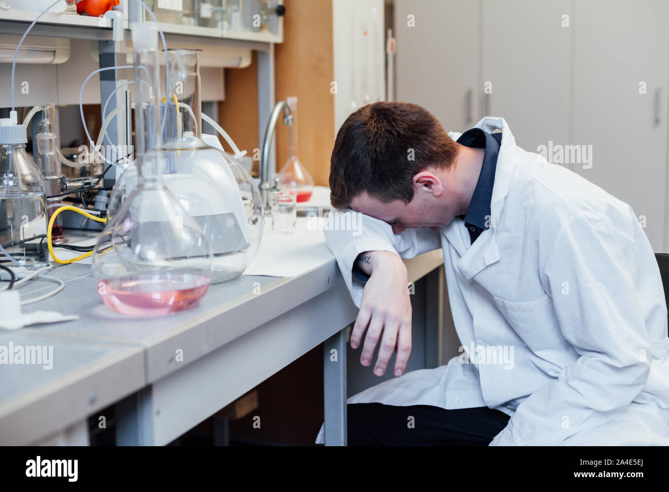 Jeune scientifique dort dans des expériences chimiques de laboratoire Banque D'Images