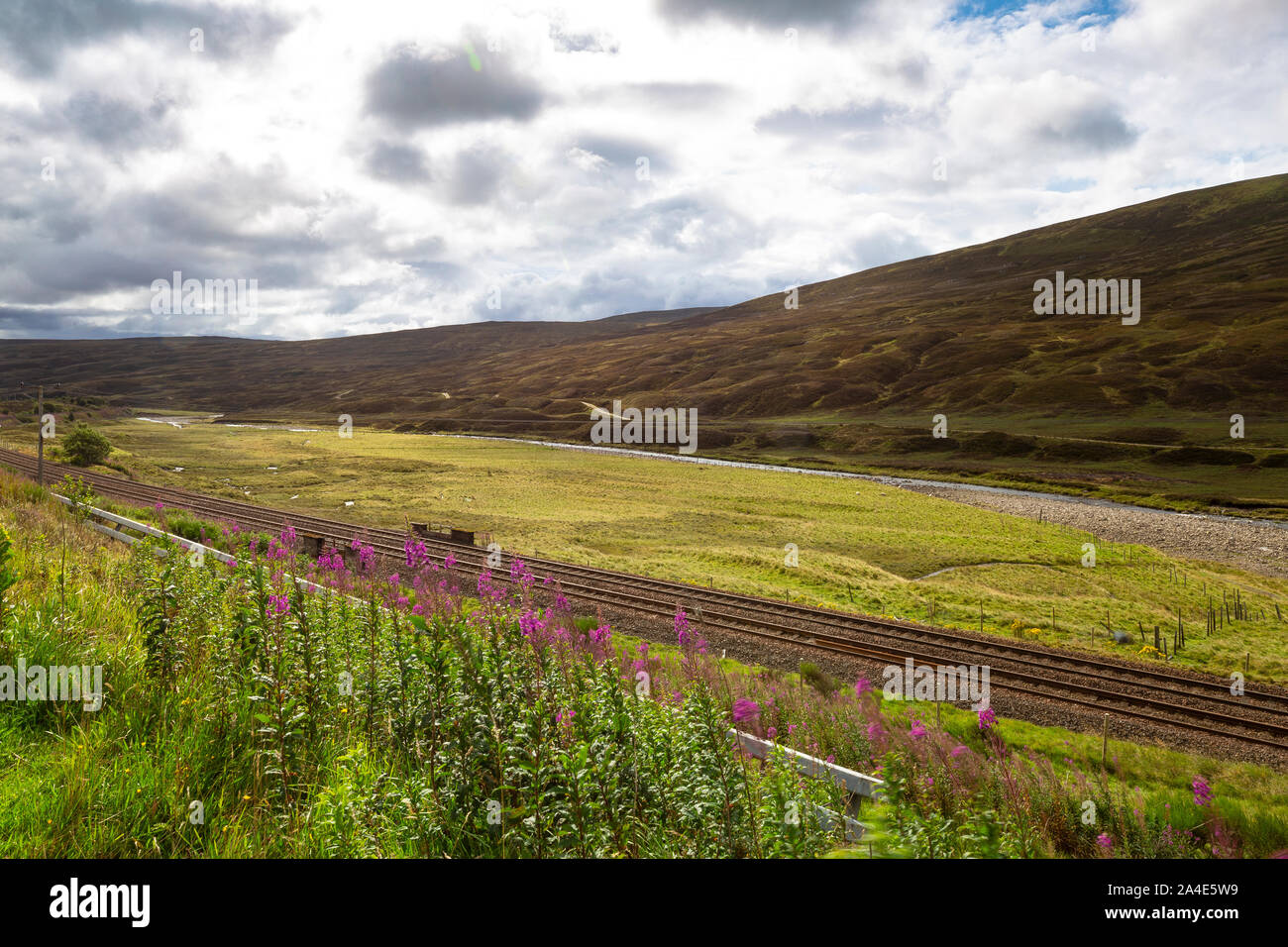 Vue sur la rivière Garry avec voie ferrée et paysage montagneux. Pitlochry, Ecosse Banque D'Images