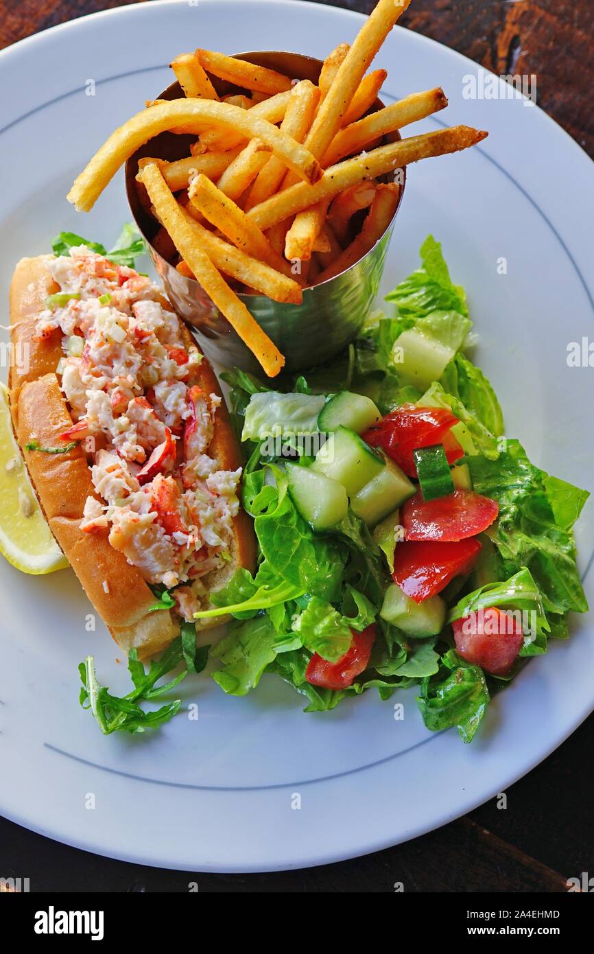 Un rouleau de homard sandwich avec une salade verte et de frites Banque D'Images