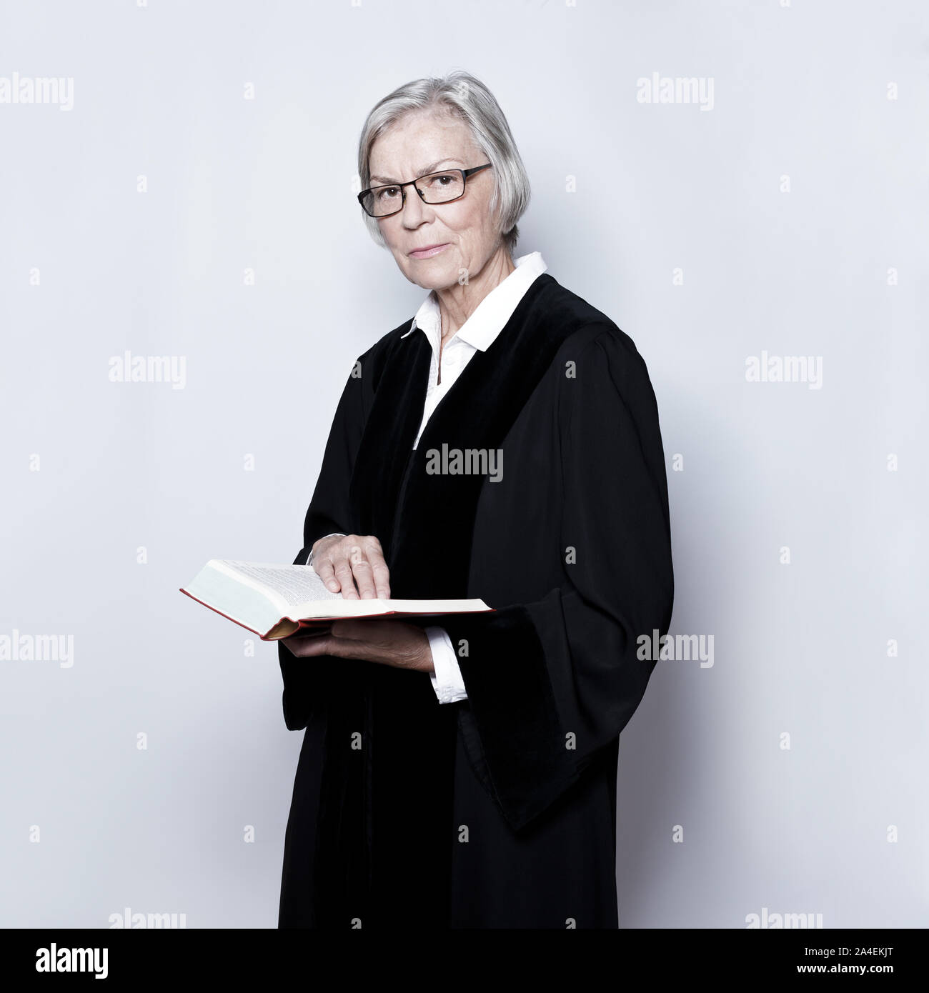 La femelle mature femme : concept allemand dans un juge noir robe de lecture dans un texte législatif d'adresses. Banque D'Images