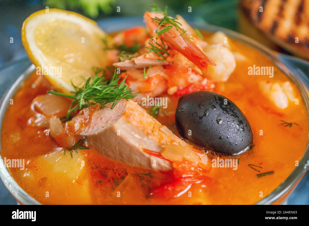 Les fruits de mer, saumon et soupe à la morue avec des pommes de terre. Servi avec du citron, les olives et délicieux croûtons de pain blanc. Close up. Banque D'Images