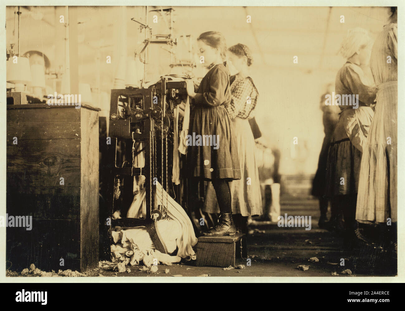 Cette petite fille (comme beaucoup d'autres dans cet état) est si petite qu'elle doit se tenir sur une case pour atteindre sa machine. Elle est régulièrement utilisé comme un producteur de tricots à Londres [c.-à-d., Loudon Banque D'Images