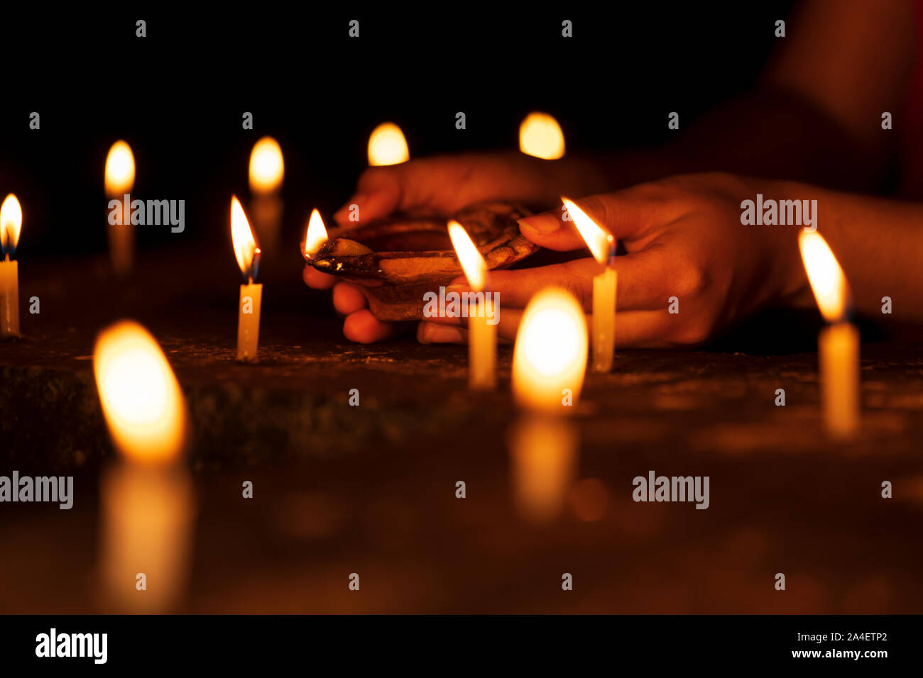 Femme mains tenant un Diya, éclairage des bougies dans les célébrations du Diwali nuit au temple. Concept d'arrière-plan pour les rituels hindous indiens, de culte, de croire Banque D'Images