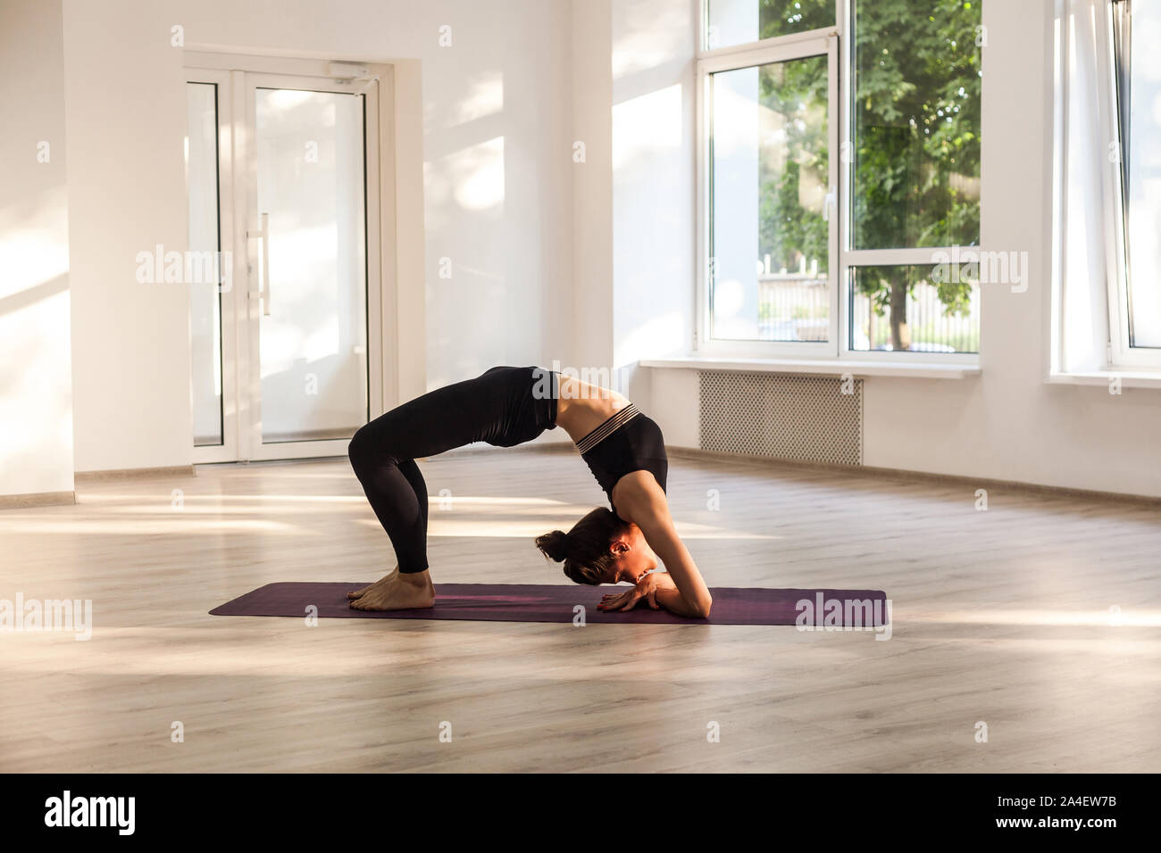 Les jeunes adultes yogi attrayant woman practicing yoga, stretching en exercice, pont coudé pada dvi viparita dandasana posent, de l'exercice, vêtu de noir s Banque D'Images