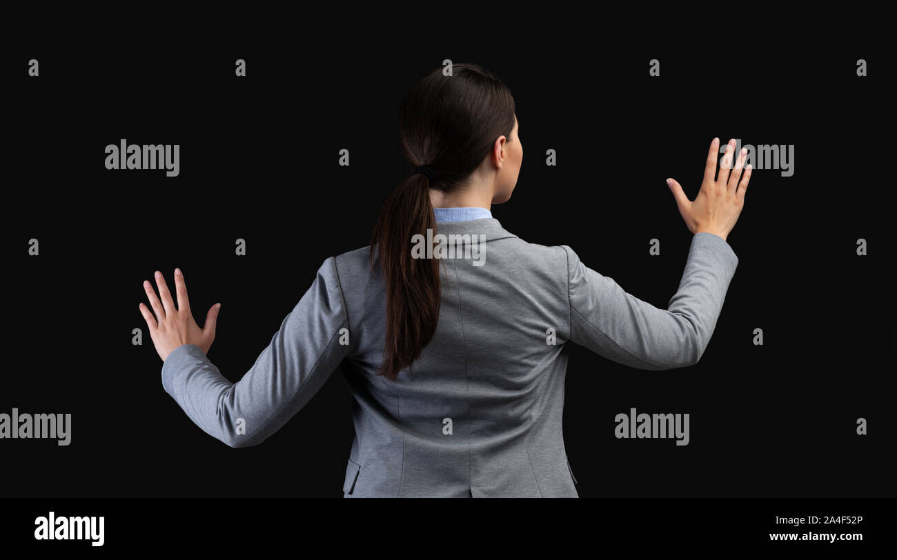 Businesswoman Using Virtual Touchpad debout sur fond noir, Panorama Banque D'Images