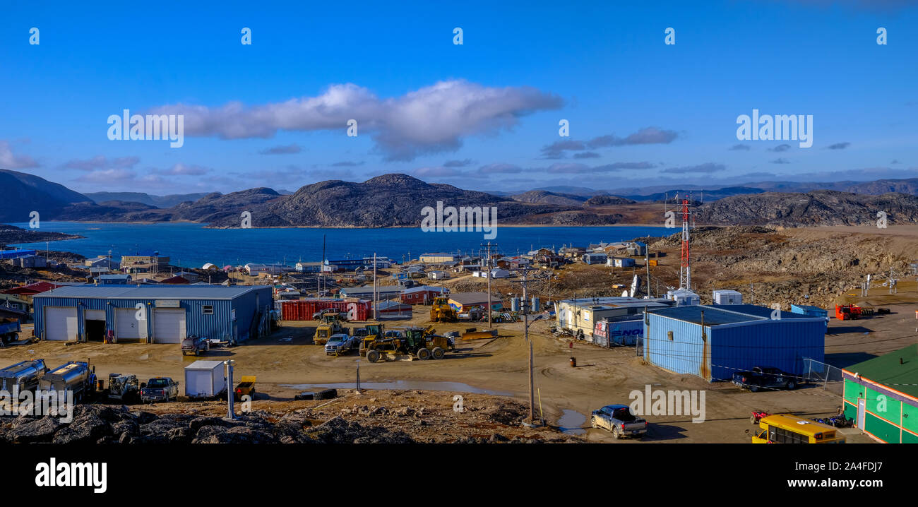 Panorama de l'ensoleillée ville Inuit Kinngait (Cape Dorset) au Nunavut, Canada prises à partir de la colline à côté de l'aéroport. Vue montre la ville, l'eau, montagnes, nuages. Banque D'Images
