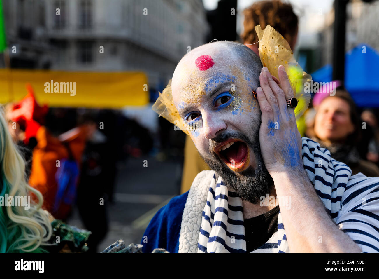 Londres, Royaume-Uni. Un manifestant avec un maquillage audacieux appliqué frappe une pose à Oxford Circus lors de la protestation contre la rébellion de l'extinction. Banque D'Images