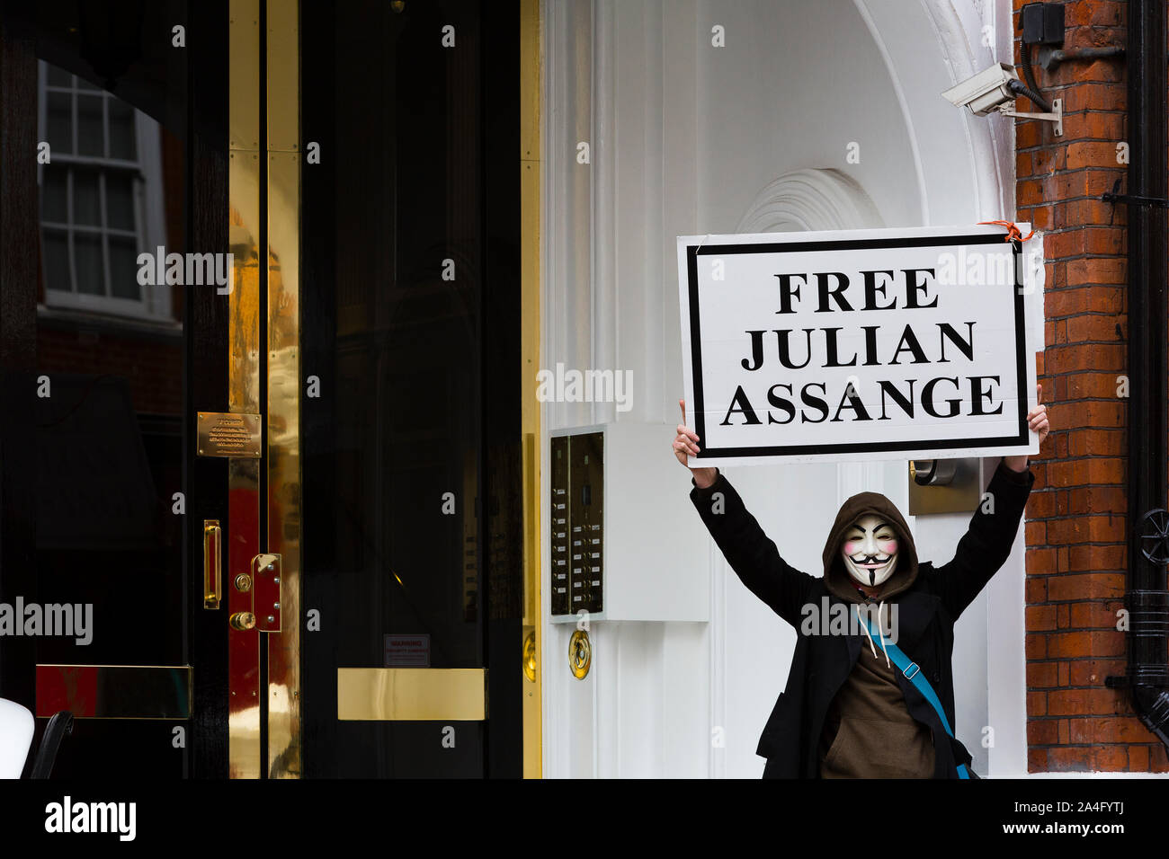 Londres, Royaume-Uni. Un manifestant dans un masque de Guy Fawkes est titulaire d'un 'gratuitement' Julian Assange placard sur les marches de l'ambassade équatorienne à Knightsbridge en anticipa Banque D'Images