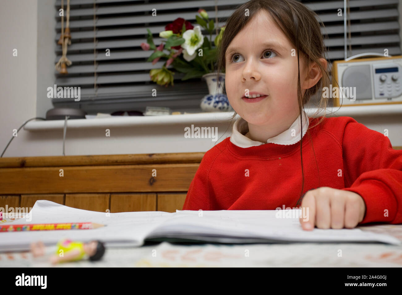 6 ans, fille, assis à table de cuisine faire ses devoirs Banque D'Images