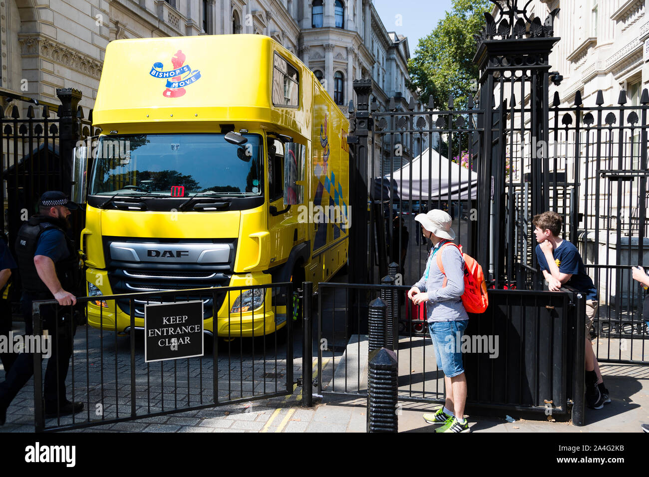 Londres, Royaume-Uni. Un déplacement de l'évêque jaune camion renverse dans Downing Street comme Boris Johnson assume le poste de premier ministre. Banque D'Images