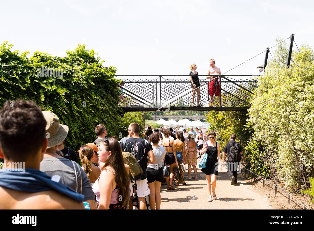 Londres, Royaume-Uni. Une énorme queue de nageurs attend d'entrer dans le Lido à Hyde Park. Banque D'Images