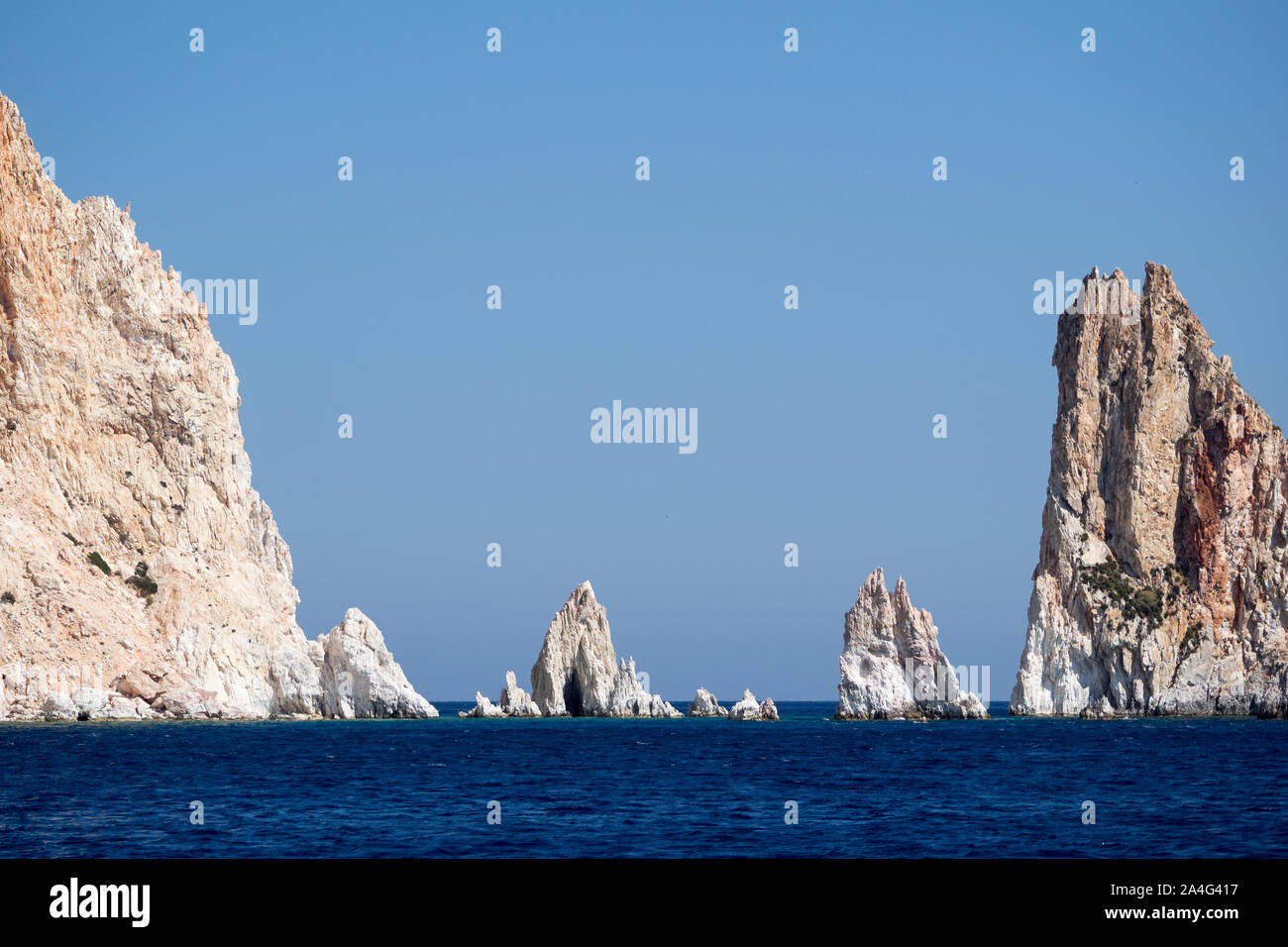 Une vue de Poliegos jaggered aiguilles sharp dents roches Péloponnèse, Grèce dans le calme de l'eau de mer sous ciel bleu clair Banque D'Images