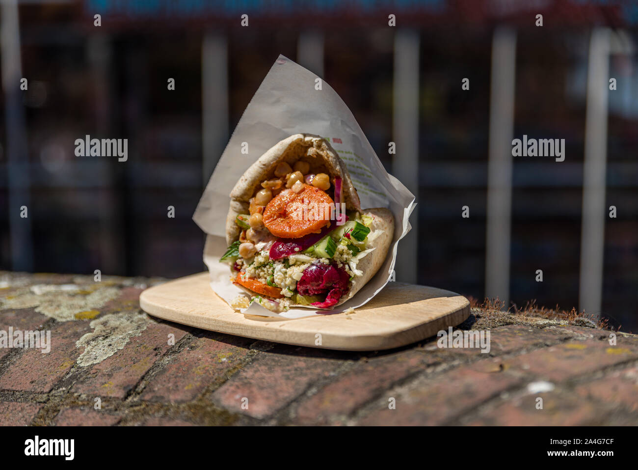 Belle pita falafel sur une plaque de bois à l'extérieur sur un mur de briques Banque D'Images