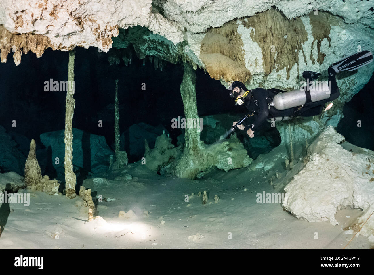 Un plongeur explore la grotte des passages de la célèbre Mexique Dos Ojos Cenote. Banque D'Images