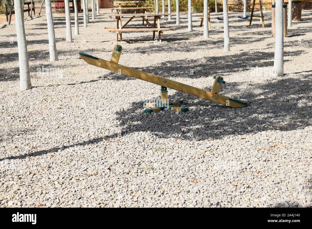 Balançoire en bois dans un parc public par un après-midi d'été, entouré d'arbres Banque D'Images