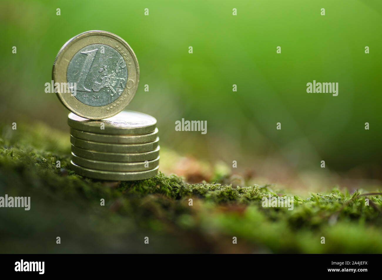Une pièce en euro sur la pile de pièces de monnaie en argent vert - Nature Banque D'Images