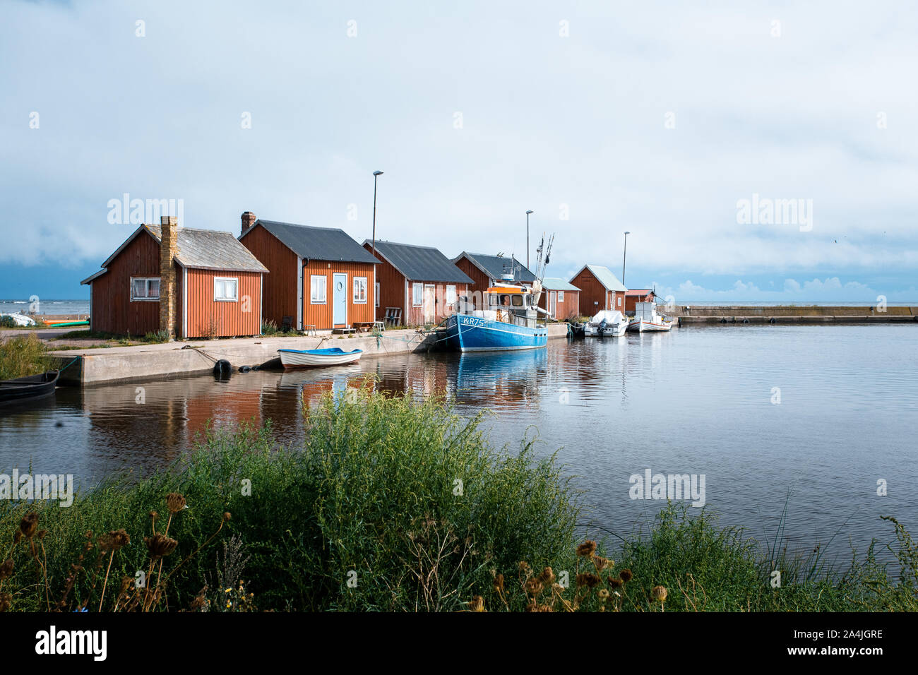 Petit port avec bateau de pêche bleu en face en Suède Banque D'Images