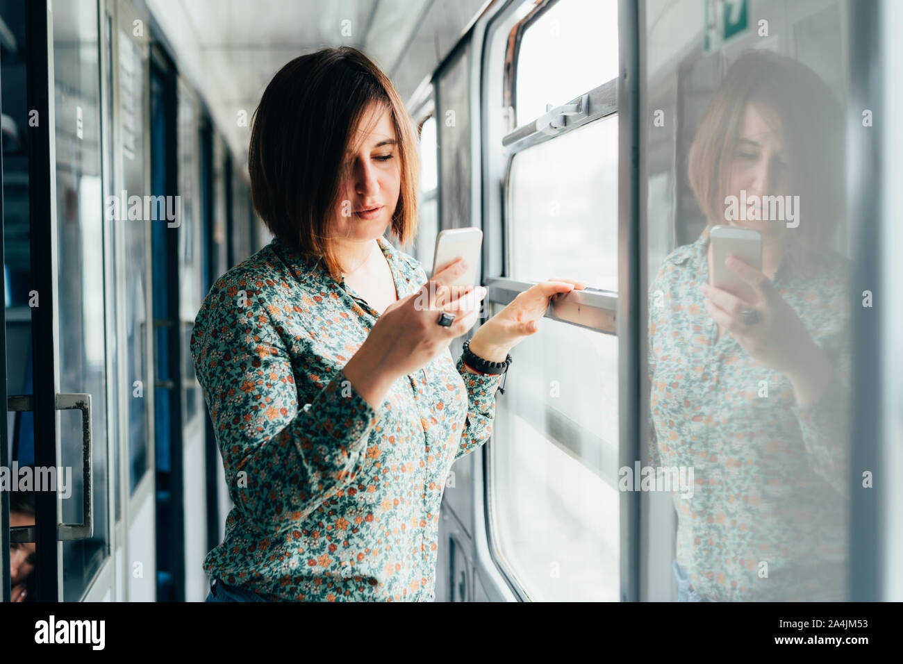 Jolie femme brune dans une chemise avec un téléphone dans sa main Banque D'Images