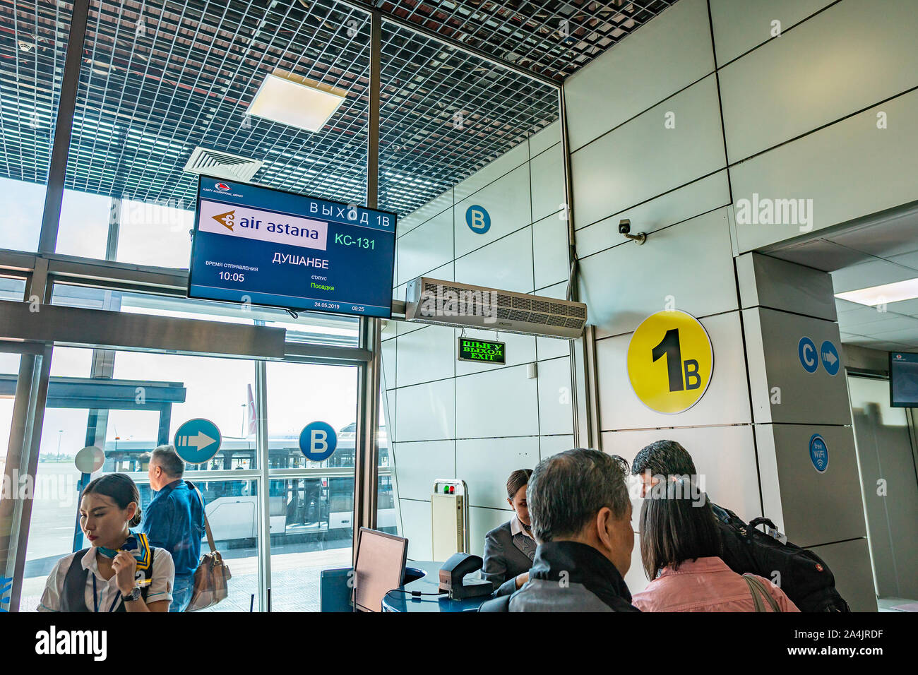 Les gens de l'Aéroport International d'Almaty à porte de départ sont à l'embarquement pour leur vol vers Dushanbe avec Air Astana Banque D'Images