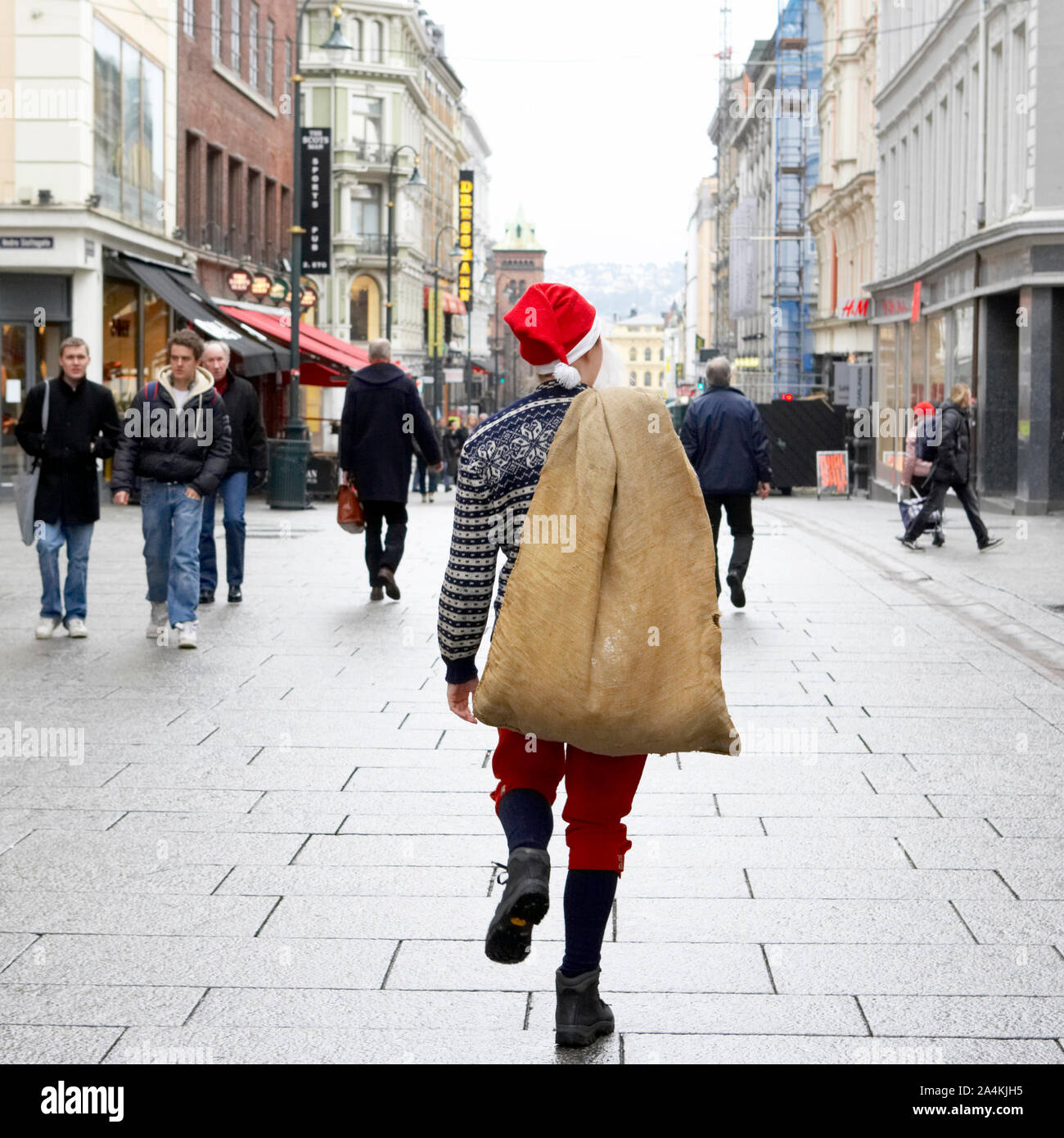 Père Noël en milieu urbain. Marcher dans la rue. Avec sac. Banque D'Images