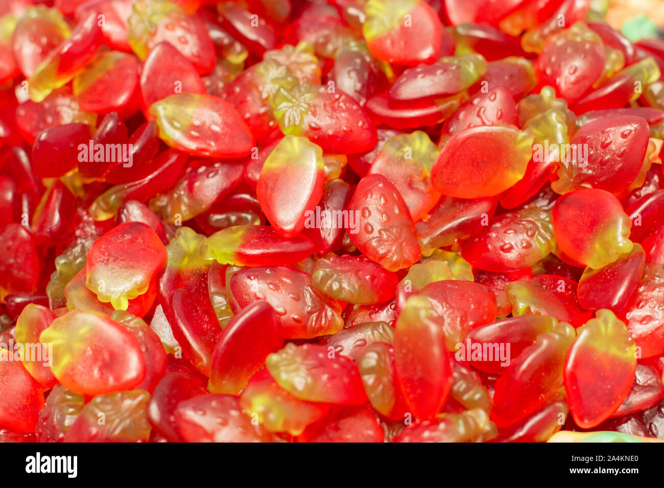 Marmelade de fraises en forme de petits fruits rouges mûrs, fond les bonbons gélatineux close-up. Bonbons à l'épicerie comptoir. Banque D'Images
