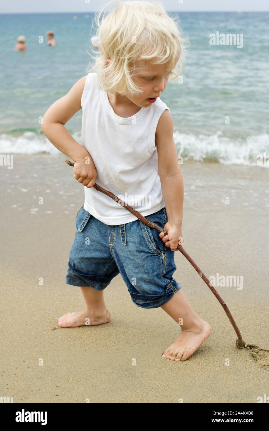 Dessin de l'enfant dans le sable humide Banque D'Images