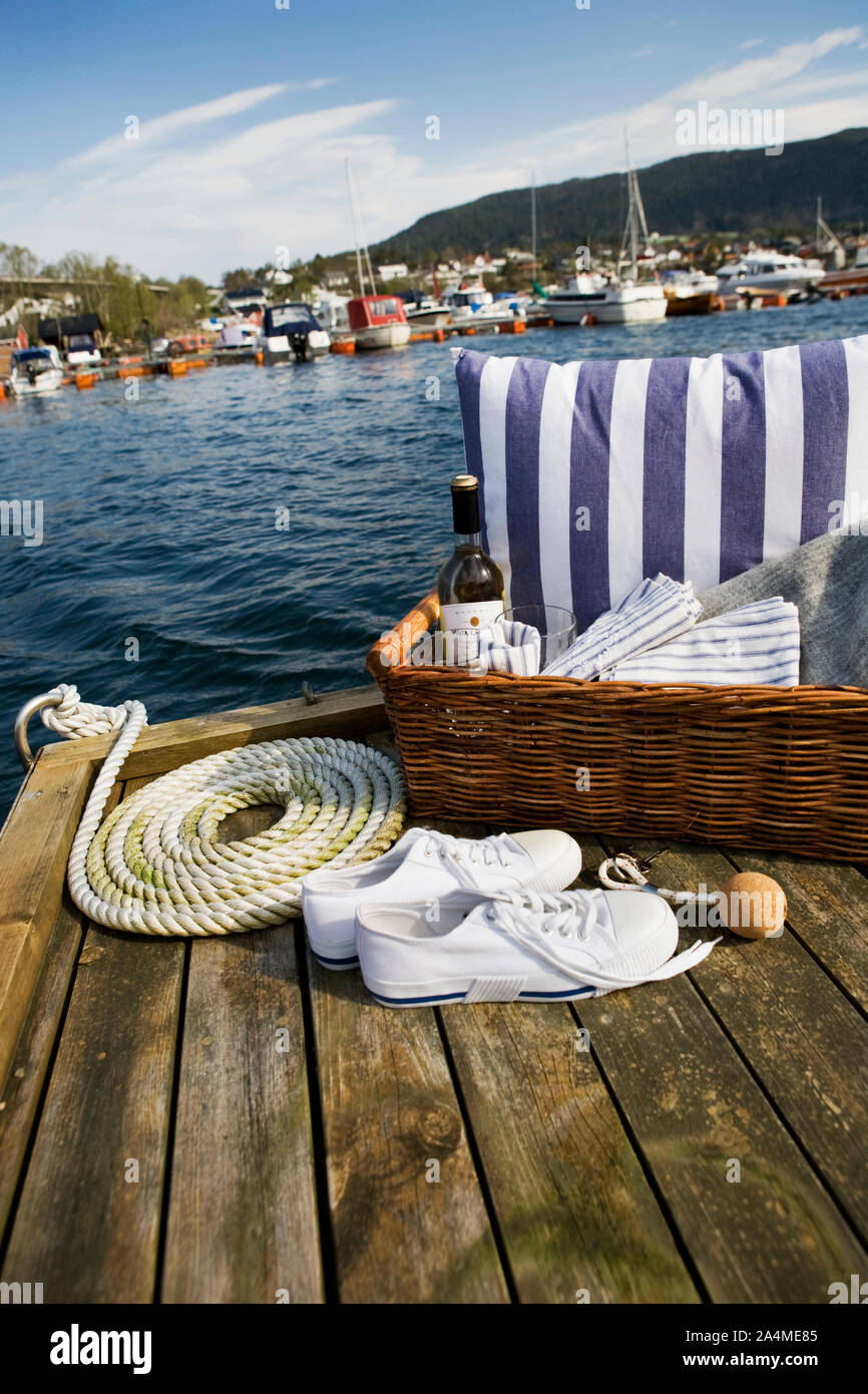 Bouteille de vin et panier sur une jetée Banque D'Images