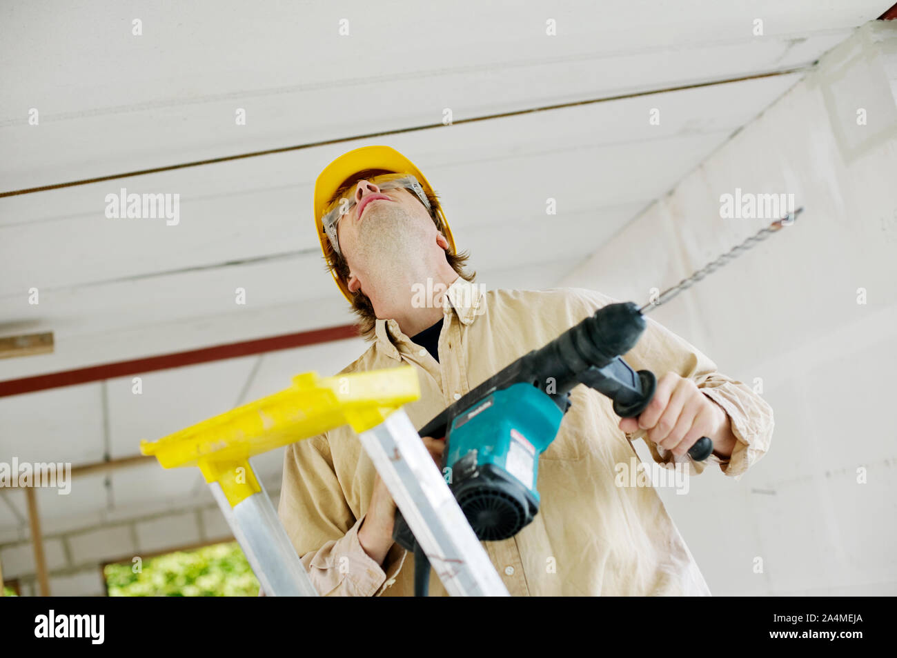 Builder la fixation d'un plafond - jaune hard hat Banque D'Images