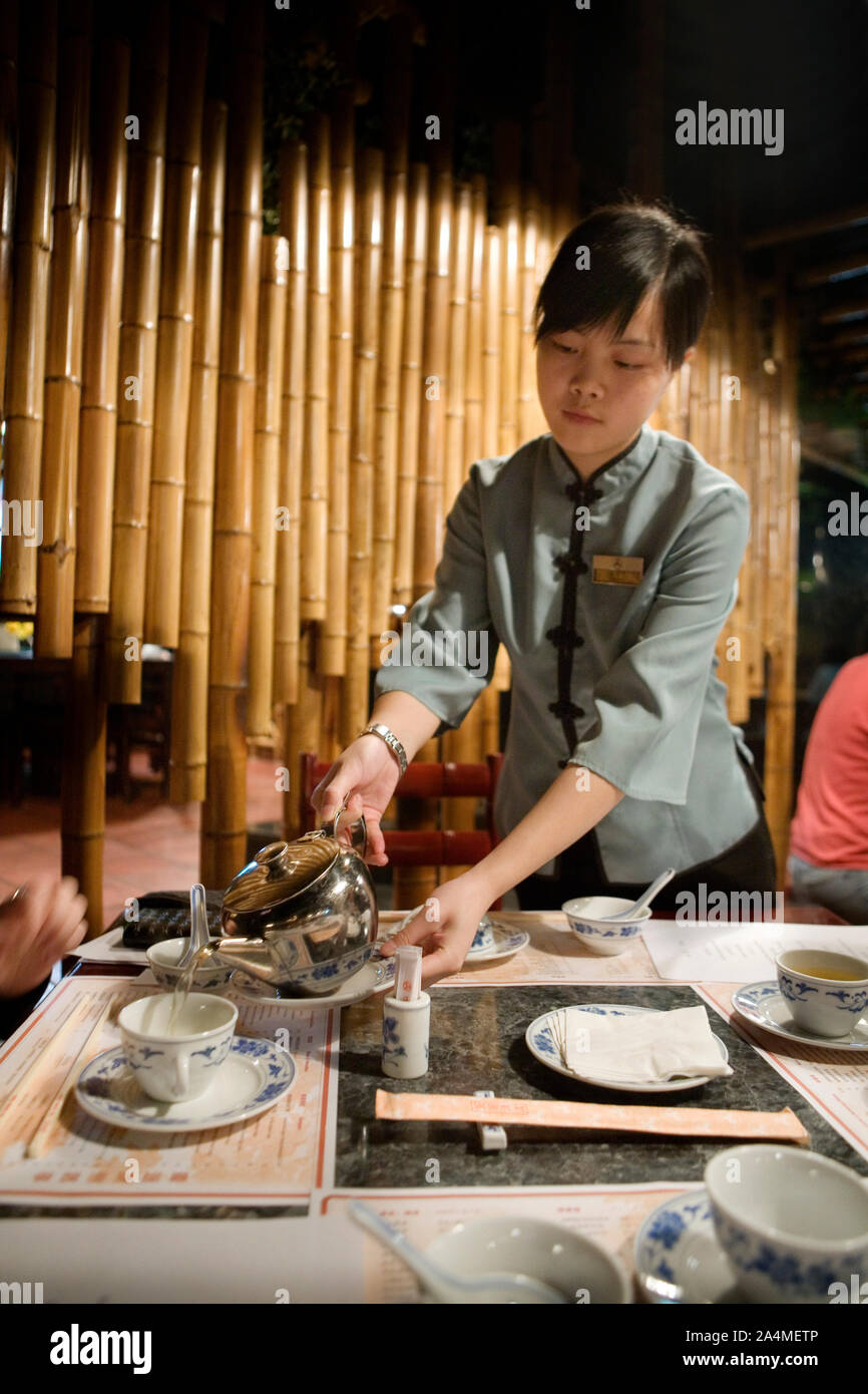 Waitress serving Dim Sum et un plateau à Guangzhou, Chine Banque D'Images