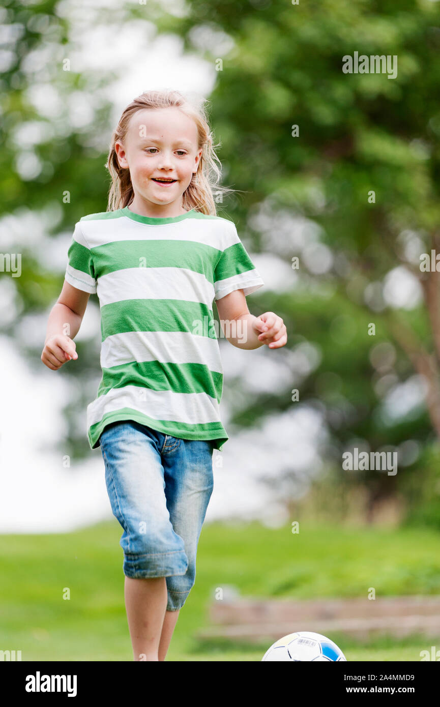 Smiling girl playing football Banque D'Images