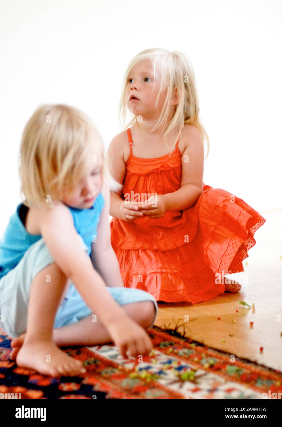 Garçon et fille jouant sur un tapis Banque D'Images