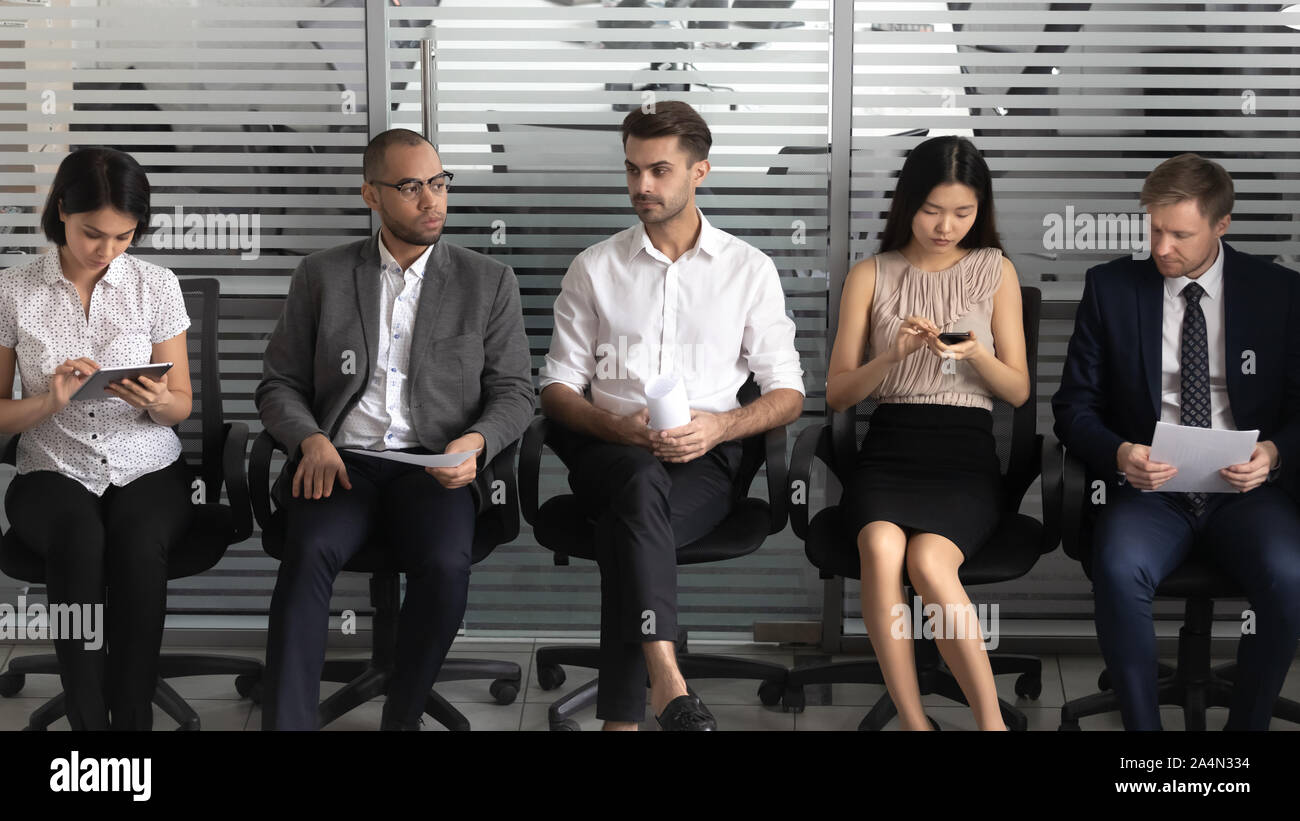 Diverses personnes, les candidats assis dans la rangée, en attente d'entrevue d'emploi Banque D'Images