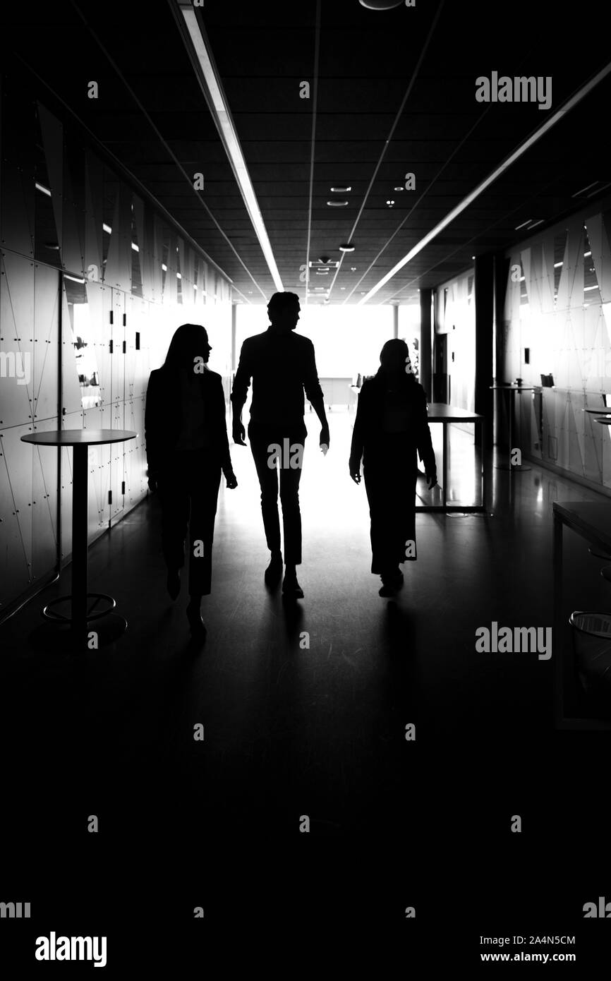 Silhouettes de personnes marchant à travers du corridor de Banque D'Images