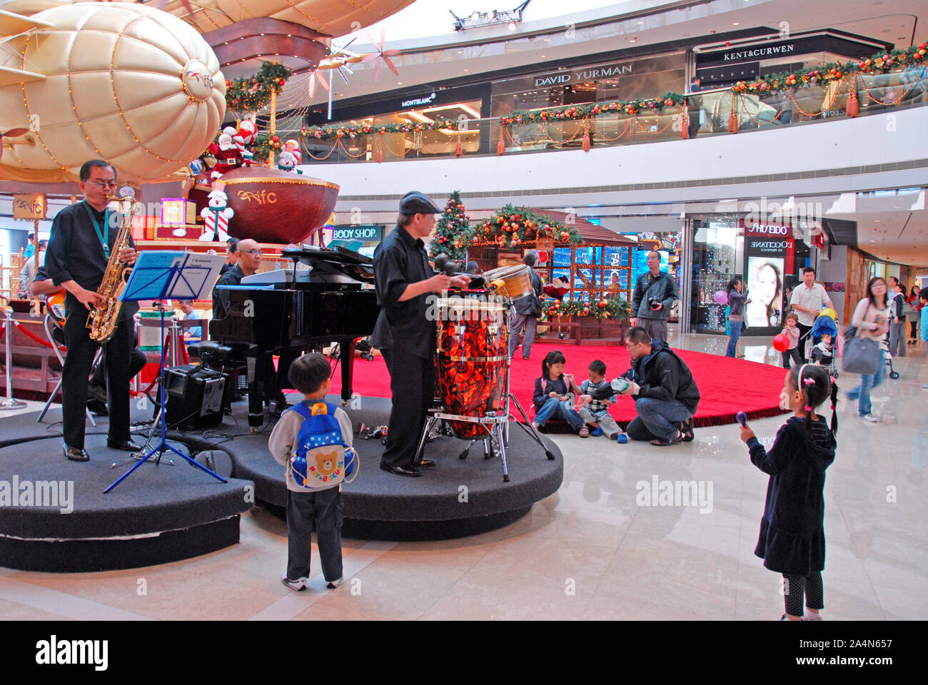 Les enfants en face d'une animation musicale à l'intérieur d'un centre commercial, l'île de Hong Kong, Chine Banque D'Images