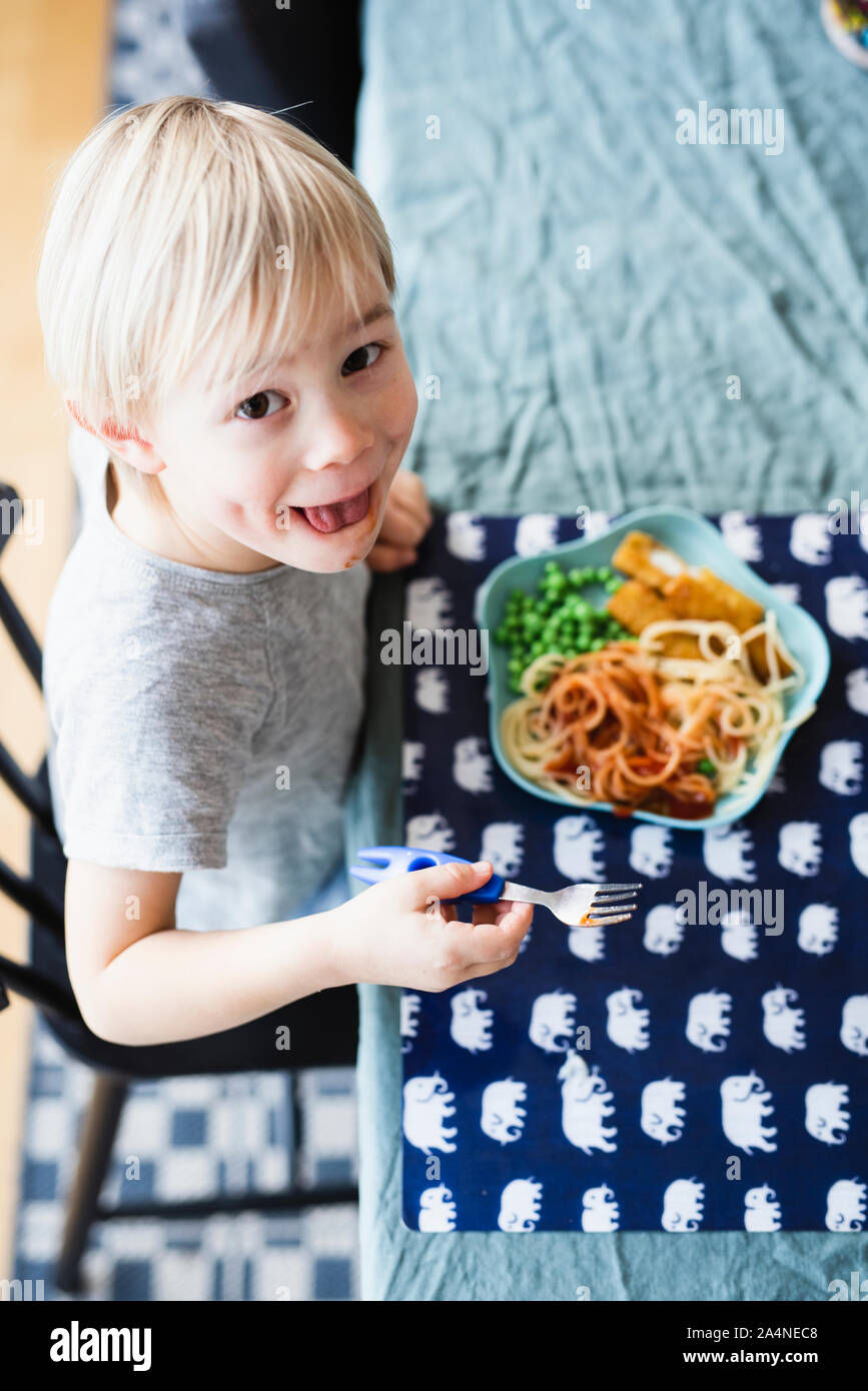 Boy eating pasta Banque D'Images