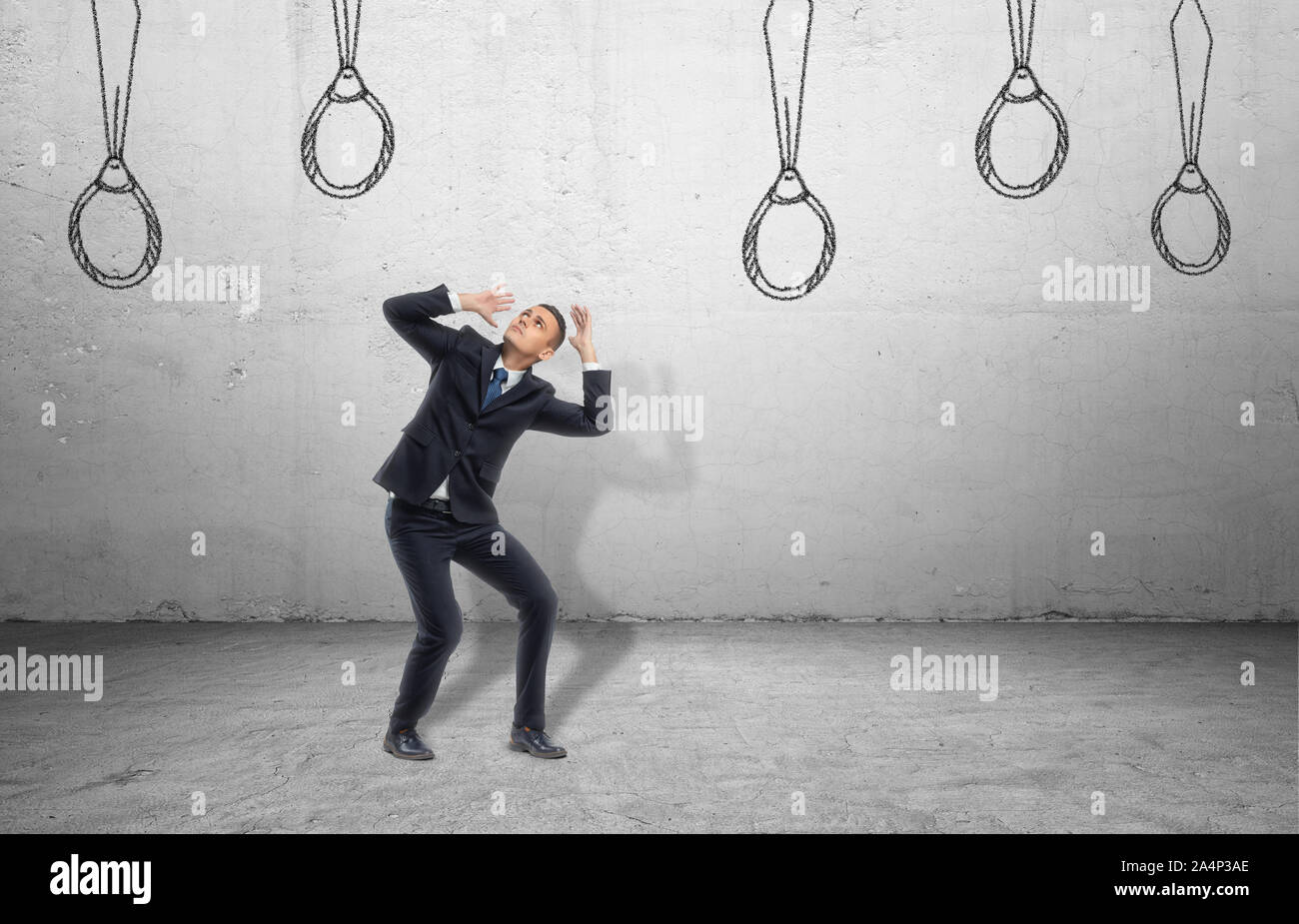 Businessman entouré par des liens tirés sur mur, qui ressemblent à des nooses. Banque D'Images