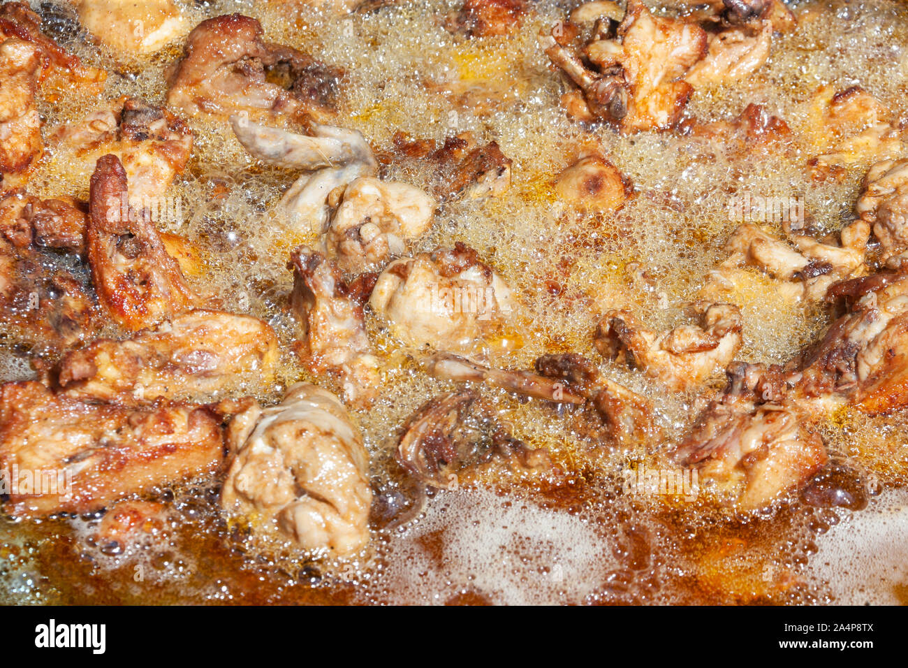 La nourriture traditionnelle africaine, du poulet frit, cuit à l'extérieur dans la cour dans un grand pot et beaucoup d'huile Banque D'Images