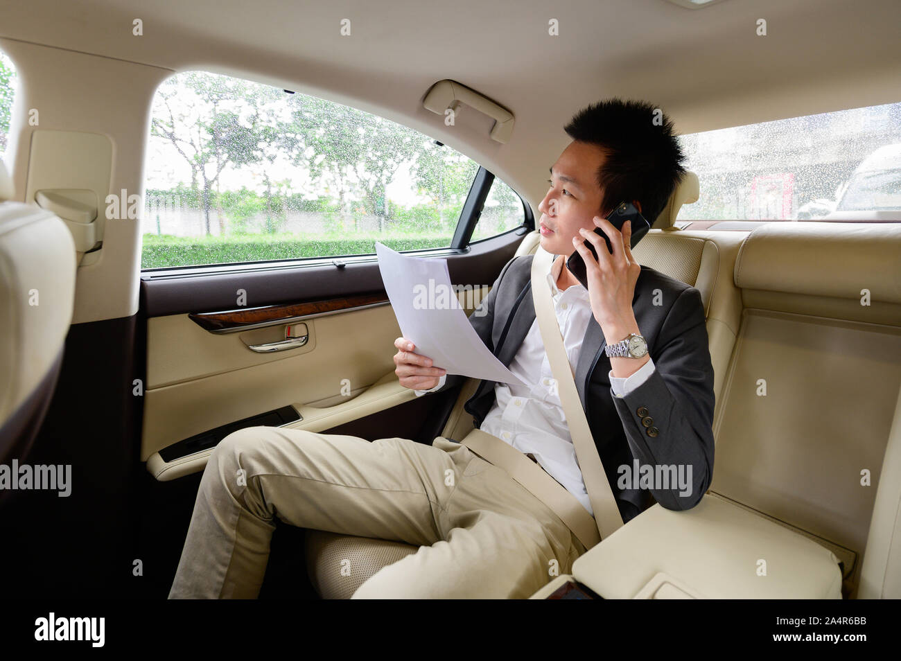 Asian man talking on mobile phone de la fenêtre Banque D'Images