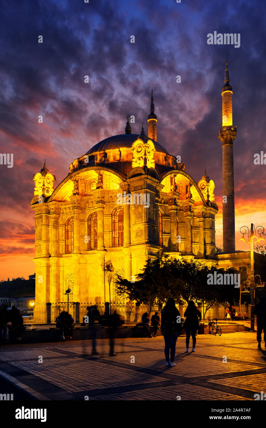 Mosquée Ortakôy à Istanbul au coucher du soleil. Ciel dramatique. L'une des principales attractions d'Istanbul. Silhouettes de personnes, les visages ne sont pas reconnaissables. La Turquie Banque D'Images