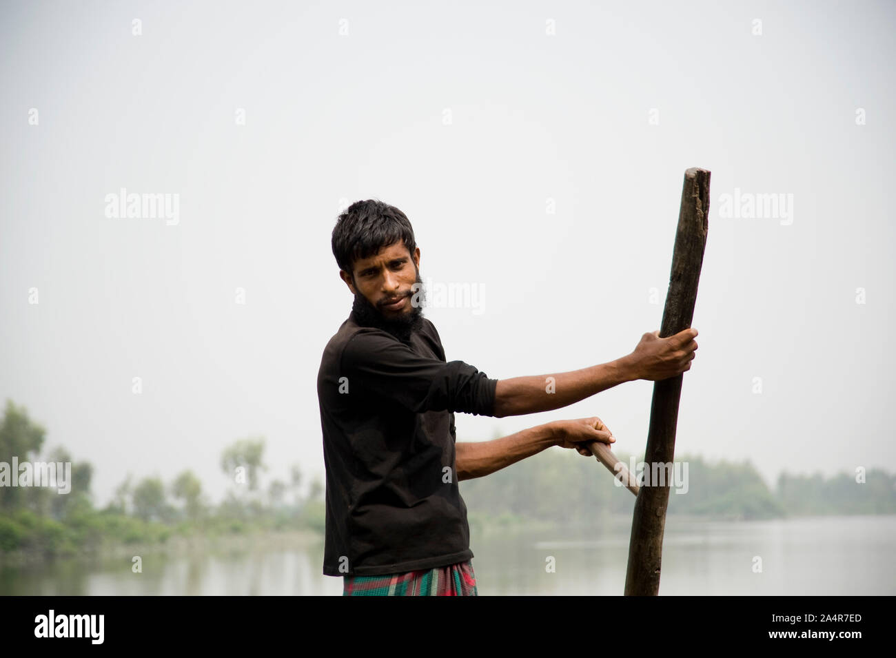 Modelrelease no : 025.Md. Harunur Rashid, 28 ans, un jeune collectionneur de palmier nipa posé pour des photographies dans les mangroves des Sundarbans, le 10 mars 2009, Khulna, Bangladesh. Palmier Nipa connu localement comme Golpata, est un membre de la famille des Arecaceae ou Palmae. C'est une espèces de palétuviers, trouvés le long des berges de rivières et cours d'eau à travers l'Asie, l'Océanie et de la côte est de l'Afrique. Il a régulièrement besoin d'inondation. Dans les Sundarbans il pousse dans des zones légèrement et modérée. Les gens habitués à faire de palmier nipa toit de maison. Banque D'Images