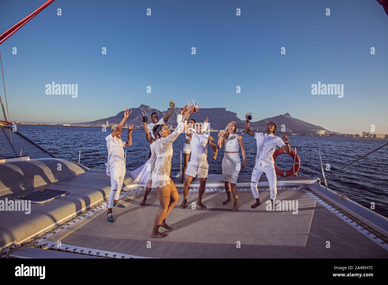 Des gens habillés en blanc le grillage sur un yacht Banque D'Images