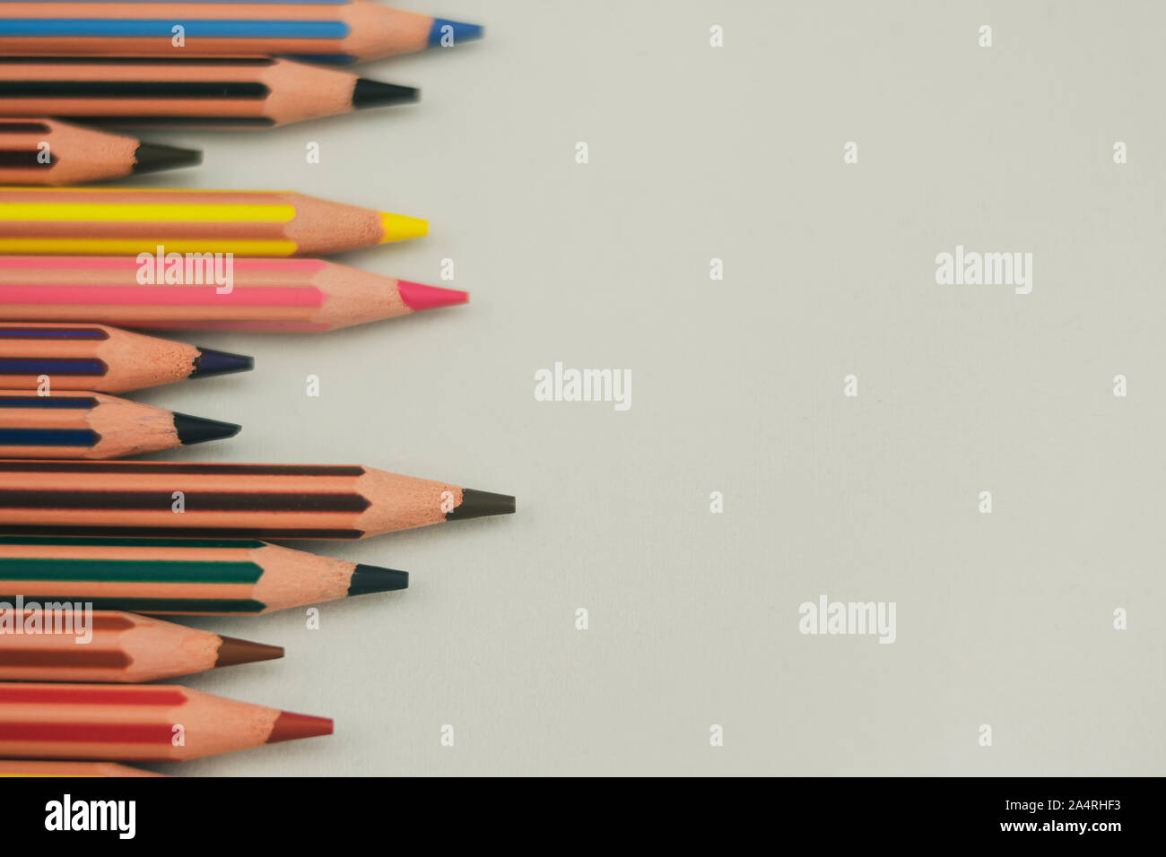 Crayons de couleur Sharp pas alignés horizontalement et situé sur le côté gauche sur fond blanc Banque D'Images