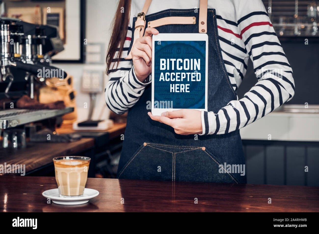Close up woman holding tablet barista et montrer acceptés ici bitcoin sur écran de tablette au café bar comptoir café,le vendeur accepte le paiement par crypto Banque D'Images