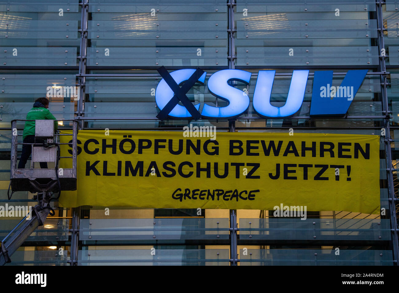 Munich, Allemagne. 16 Oct, 2019. Les militants de l'organisation Greenpeace modifier le logo à la direction de la CSU. Avec une action de protestation à l'administration centrale du parti CSU, les écologistes de Greenpeace dénonce la politique climatique de l'Union européenne. Tôt mercredi matin, des militants ont conduit un chariot élévateur en face de l'immeuble à Munich et a changé la partie logo sur la façade en verre : 'CSU' est devenu' (véhicules utilitaires sport). Credit : Lino Mirgeler/dpa/Alamy Live News Banque D'Images