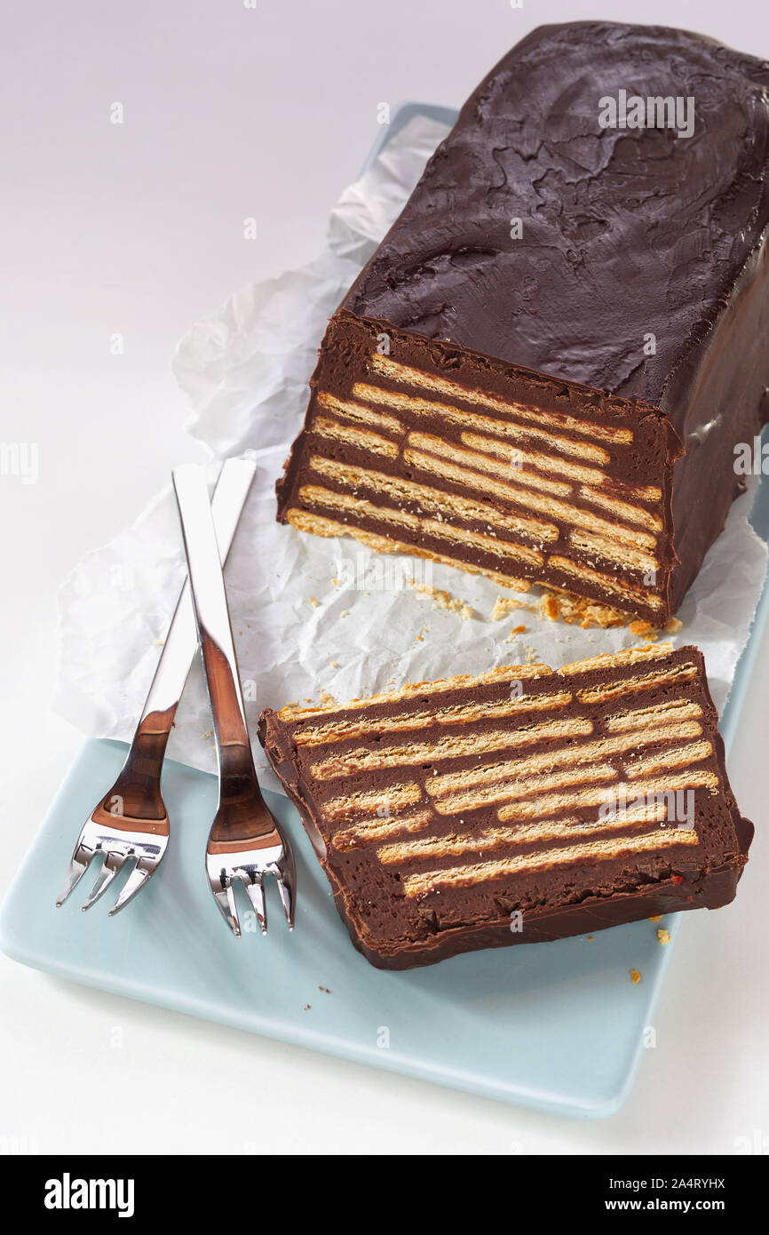 En Forme De Pain Gateau Au Chocolat Sans Cuisson Coupe Herisson Ou Kalter Hund Avec Des Couches De Biscuits Entiers A L Interieur De Glacage Au Chocolat Et Marron Servi Sur Bleu Ceram En Forme De Pain Gateau Au Chocolat Sans Cuisson Coupe Herisson Ou Kalter Hund Avec Des Couches De Biscuits Entiers A L Interieur De Glacage Au Chocolat Et Marron Servi Sur Bleu Ceram